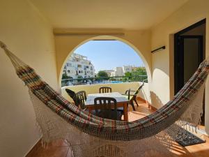 een hangmat op een balkon met een tafel en stoelen bij T1 Poente da Aldeia 336 Albufeira in Albufeira