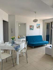 a living room with a table and a blue couch at Casa Vacanze Matilde Marzamemi in Marzamemi