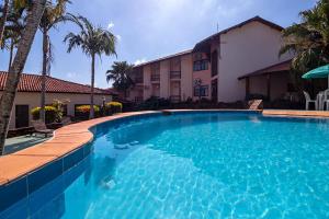 a large blue swimming pool in front of a house at Hotel Vivenda das Cachoeiras in Brotas
