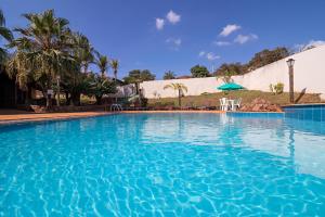 a large swimming pool with blue water at Hotel Vivenda das Cachoeiras in Brotas