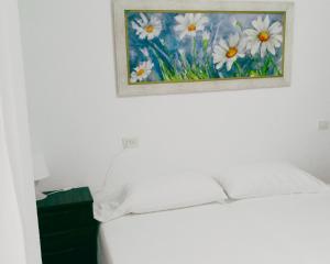 a painting of daisies on the wall above a bed at VINARÒS PLAYA CENTRO in Vinarós