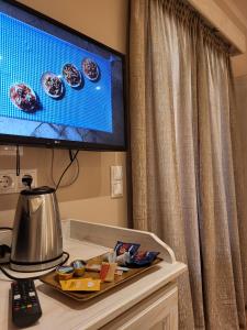 sala de estar con TV y mesa en BELLA VITA boutique hotel lefkada, en Lefkada