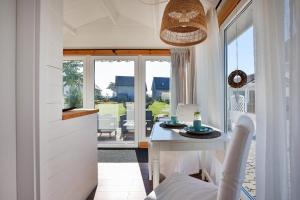 a kitchen with a white table and a dining room at Dom Goscinny "Marta" in Dziwnówek