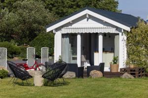 a small white gazebo with chairs and a table at Dom Goscinny "Marta" in Dziwnówek