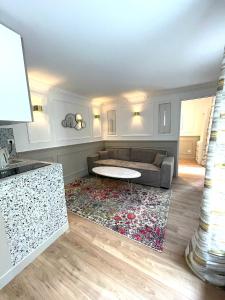 een woonkamer met een bank en een tafel bij Suite Adèle Passy in Parijs