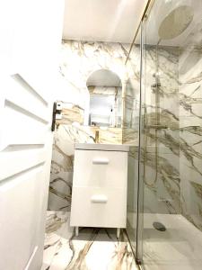 een badkamer met marmeren muren en een douche bij Suite Adèle Passy in Parijs