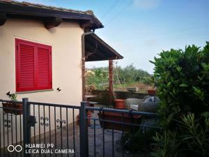カスティリオーネ・デッラ・ペスカーイアにあるCase vacanze Santamargheritaの赤窓と柵のある家