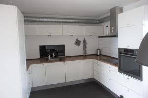 a white kitchen with white cabinets and a sink at Vesterhavsgade 47. door 25 (id. 076) in Esbjerg +5 photos