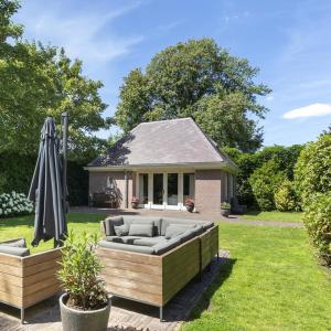 a backyard with a couch and an umbrella at Stylish Guesthouse with 2 Free E-bikes - near Breda! in Etten-Leur