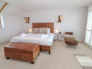 a bedroom with a large bed and a chair at Sandbanks in Penzance