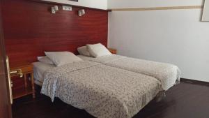 een slaapkamer met 2 bedden en een houten muur bij Casa Julián in Santa Cruz de la Palma