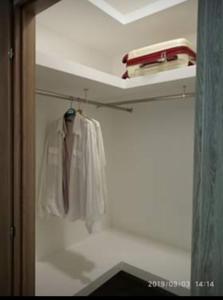 una camisa blanca y corbata colgando en un armario en Pretty House, en Casamassima