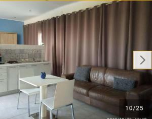sala de estar con sofá de cuero marrón y mesa en Pretty House, en Casamassima