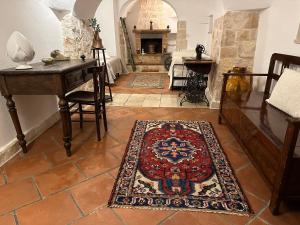 ein Wohnzimmer mit einem Tisch und einem Teppich auf dem Boden in der Unterkunft Trulli Santa Maria Odegitria Relais in Ostuni