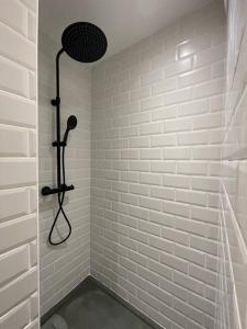 a bathroom with a shower with white tiles at Logement cosy cuisine / terrasse / BBQ in Ollioules