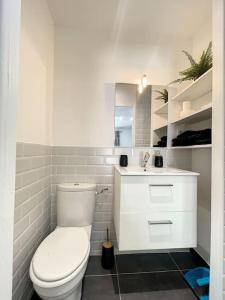 a white bathroom with a toilet and a sink at Logement cosy cuisine / terrasse / BBQ in Ollioules