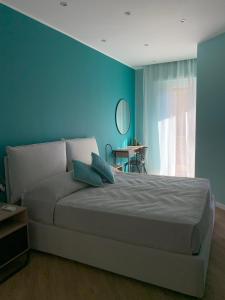 sypialnia z łóżkiem i niebieską ścianą w obiekcie HOB Via Rausei w mieście Reggio di Calabria