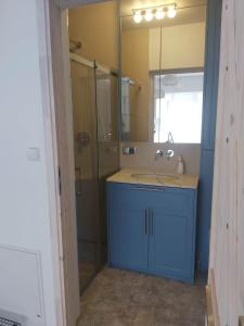 y baño con lavabo azul y ducha. en Nowe apartamenty Kuźnica Hel, en Kuźnica