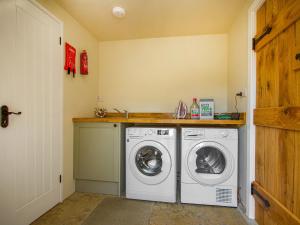 uma lavandaria com máquina de lavar e secar roupa em Avondale em Woodgreen