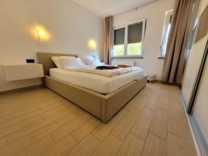 - une chambre avec un lit et du parquet dans l'établissement Apartment Karla, à Rijeka