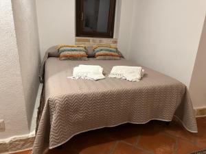 a bed with two pillows on it in a room at Trulli Santa Maria Odegitria Relais in Ostuni