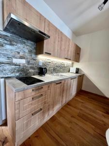 a kitchen with wooden cabinets and a sink at Ski eden in Mýto pod Ďumbierom