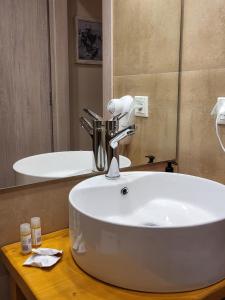 bagno con lavandino bianco e specchio di BELLA VITA boutique hotel lefkada a Città di Lefkada