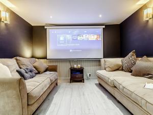 a living room with two couches and a projection screen at The Golden Crown in Tarbolton