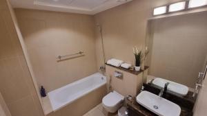 a bathroom with a tub and a toilet and a sink at Two bedroom Apartment Muscat Bay in Muscat +20 photos
