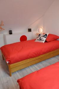 ein Schlafzimmer mit einem roten Bett mit einer roten Decke in der Unterkunft Gite le Ryokan in Wailly-Beaucamp