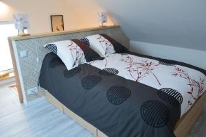 ein Bett mit einer schwarzen und weißen Bettdecke in der Unterkunft Gite le Ryokan in Wailly-Beaucamp