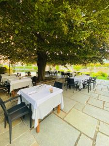 Villa Nasti Hotel Ristorante في Canzo: مجموعة طاولات وكراسي تحت شجرة