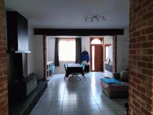 a living room with a table and a fireplace at House close to the city center in Mons