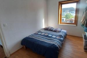 a small bed in a room with a window at House close to the city center in Mons