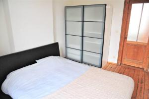 1 dormitorio con 1 cama blanca y armario de cristal en The Oasis apartment, 2 bedrooms antwerp South, en Amberes