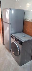 einen Kühlschrank aus Edelstahl mit einer Waschmaschine in der Küche in der Unterkunft Appart avec terrasse El Ouatia Tan Tan Plage in Tan-Tan Plage