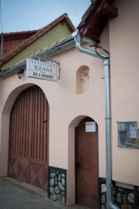a building with two garage doors and a sign on it at PENSIUNEA ILEANA "Adults Only" in Orlat