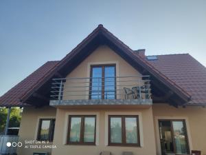 dom z balkonem na górze w obiekcie ABM Noclegi w mieście Mikołajki