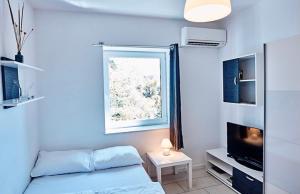 - un salon avec un lit et une fenêtre dans l'établissement Apartments & rooms Artemus Belveder, à Koper
