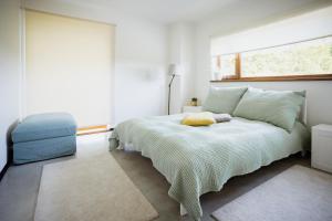 biała sypialnia z łóżkiem i oknem w obiekcie Luxury apartment close to the sea w mieście Kuressaare