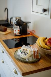 a counter top with a plate of bananas and a bowl of fruit at Luxury apartment close to the sea in Kuressaare