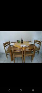 a wooden table with four chairs and a bottle of wine at Jasna 2 in Stari Grad