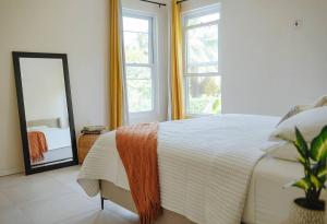 a bedroom with a large bed and a mirror at Blissful Tides in Hope Bay