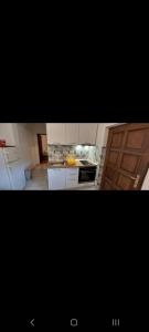 uma cozinha com armários brancos e uma porta de madeira em Jasna 2 em Stari Grad