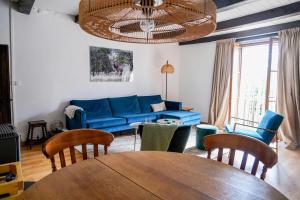 a living room with a blue couch and a table at Maison Ainvelle - with Sauna in Ainvelle