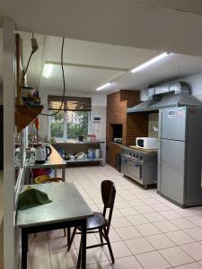 a large kitchen with a table and a refrigerator at Mang’o Hostel in Aktau