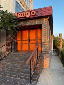 eine Garage mit orangefarbenen Türen und Treppen vor einem Gebäude in der Unterkunft Mang’o Hostel in Aqtau