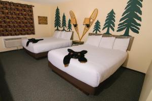Riverside Inn في Cold Spring: غرفه فندقيه سريرين عليها دبه