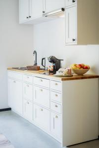 a white kitchen with a bowl of fruit on a counter at Luxury apartment close to the sea in Kuressaare