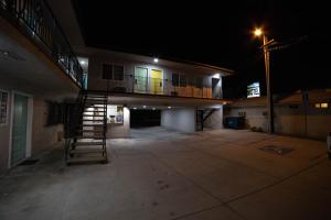 a building with a staircase in a parking lot at night at Artesia Motor Inn in Bellflower